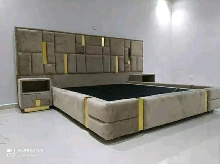 سرير كبير منجّد بالمخمل مع طاولتين جانبيتين متناسقتين